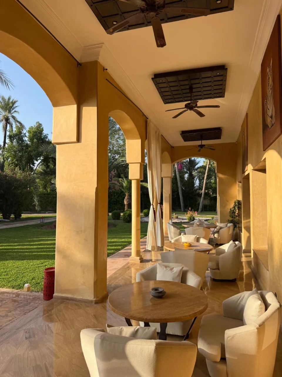 The loggia of The Palais Monte Carlo at golden hour, opening onto the Palmeraie garden