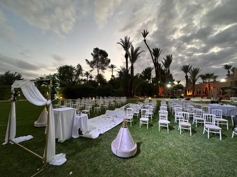The wedding arch and white aisle with rose petals at dusk