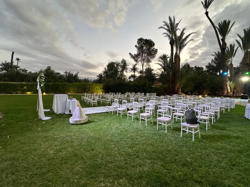 Rows of white chairs on the lawn at dusk