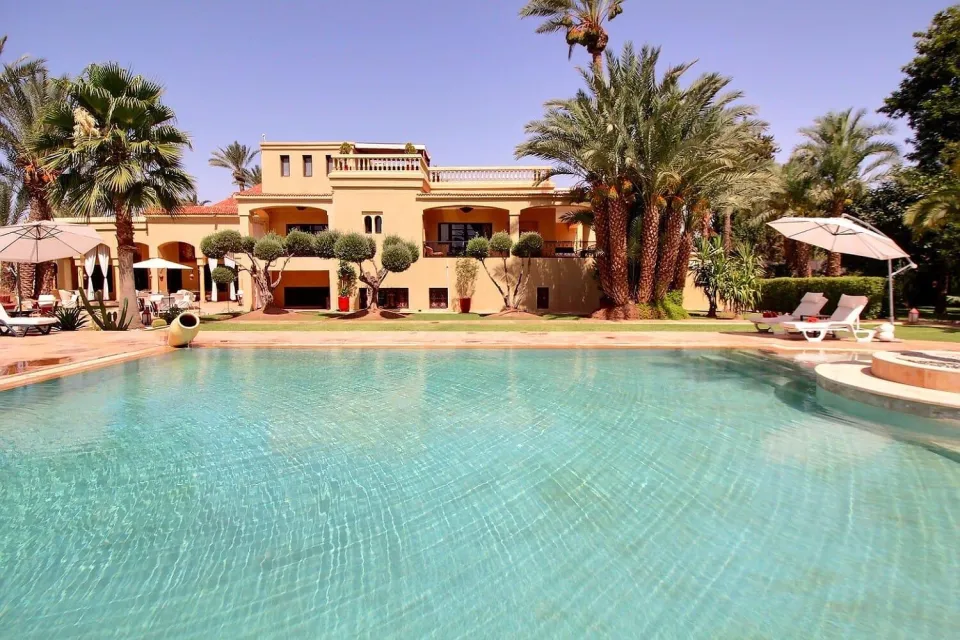 The main pool facing the palace façade among the palm trees of the Palmeraie